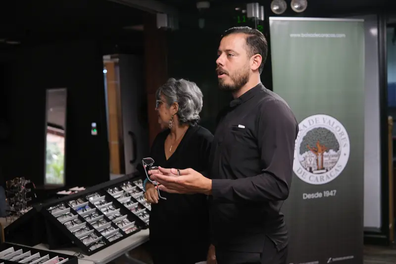 Asesor explicando las opciones a una colaboradora junto a las bandejas de monturas