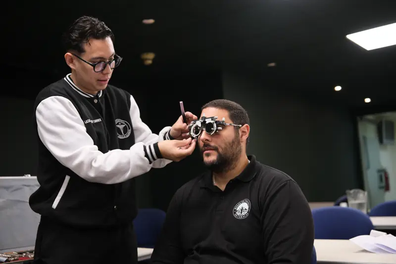 Optometrista ajustando la montura de pruebas a un colaborador